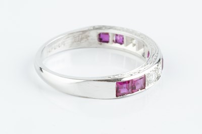 Lot 138 - A ruby and diamond half hoop ring, alternately...