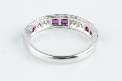 Lot 138 - A ruby and diamond half hoop ring, alternately...