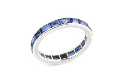 Lot 146 - A sapphire full hoop ring by Cartier, channel...