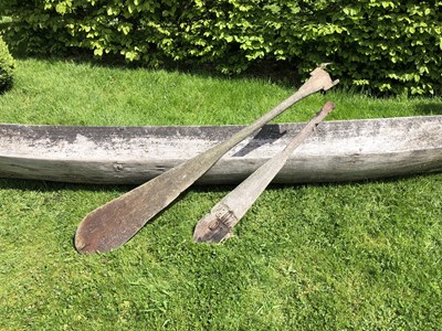 Lot 685 - An antique dugout canoe, with two paddles,...
