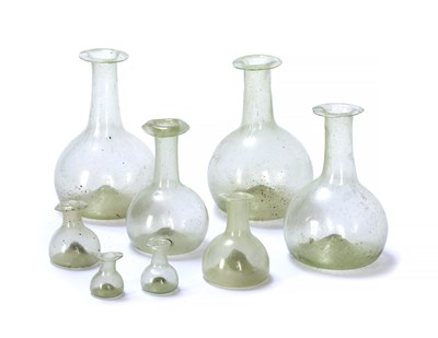 Lot 109 - A graduated set of eight aqua glass tear...