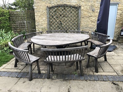 Lot 688 - A large circular oak garden table and eight...