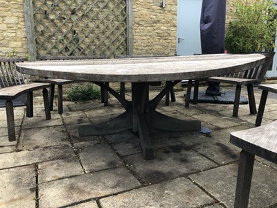 Lot 688 - A large circular oak garden table and eight...