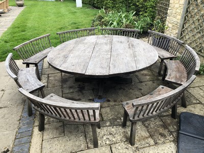 Lot 688 - A large circular oak garden table and eight...