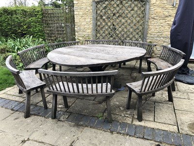 Lot 688 - A large circular oak garden table and eight...