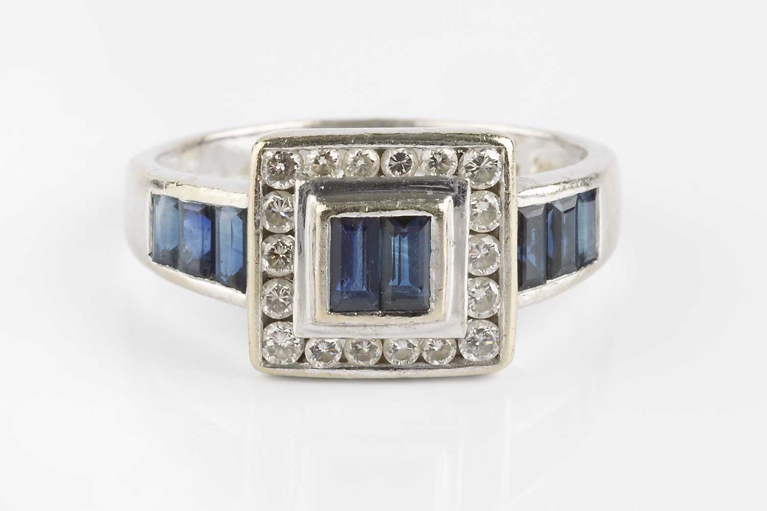 Lot 78 - A sapphire and diamond cluster ring, centred...