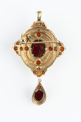 Lot 35 - A garnet set pendant/brooch, the shaped oval...