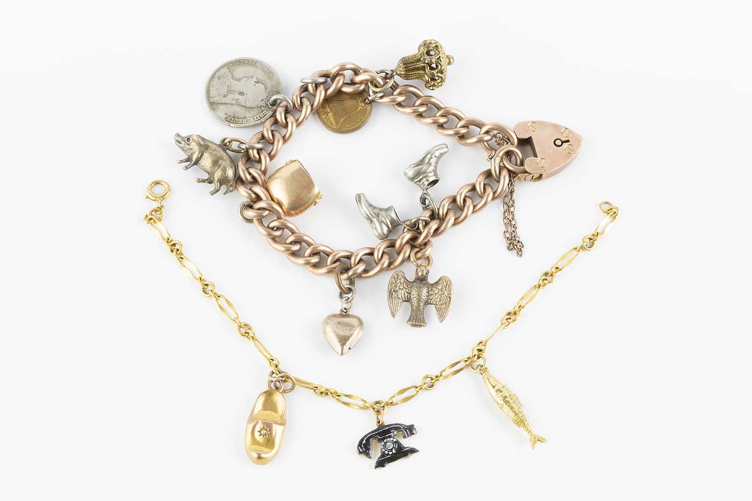 Lot 84 - Two charm bracelets, the first a hollow...