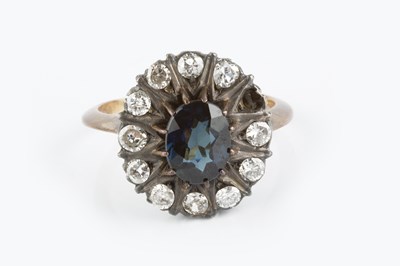 Lot 142 - A sapphire and diamond cluster ring, the oval...