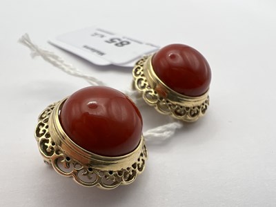 Lot 85 - A pair of coral ear clips, each coral...