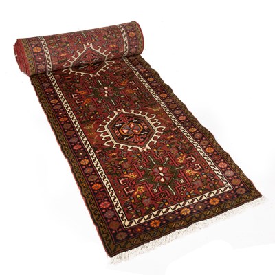 Lot 291 - A long red ground modern Oriental runner with...