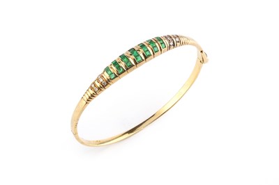 Lot 113 - An emerald and diamond bangle, of hinged oval...