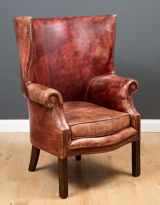 Lot 2 - A George II style leather upholstered wing...