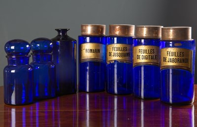 Lot 46 - A set of four blue glass cylindrical pharmacy...