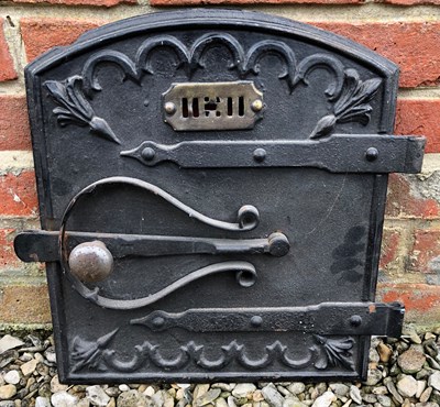 Lot 880 - An old cast iron oven door with strapwork...