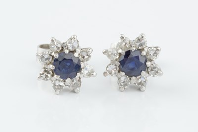 Lot 101 - A pair of sapphire and diamond cluster ear...