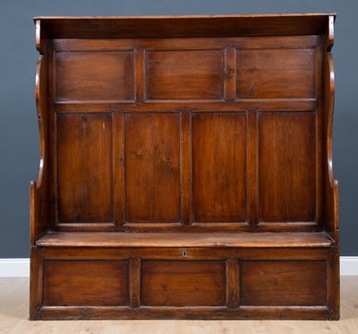 Lot 204 - An antique oak settle with panel back and box...