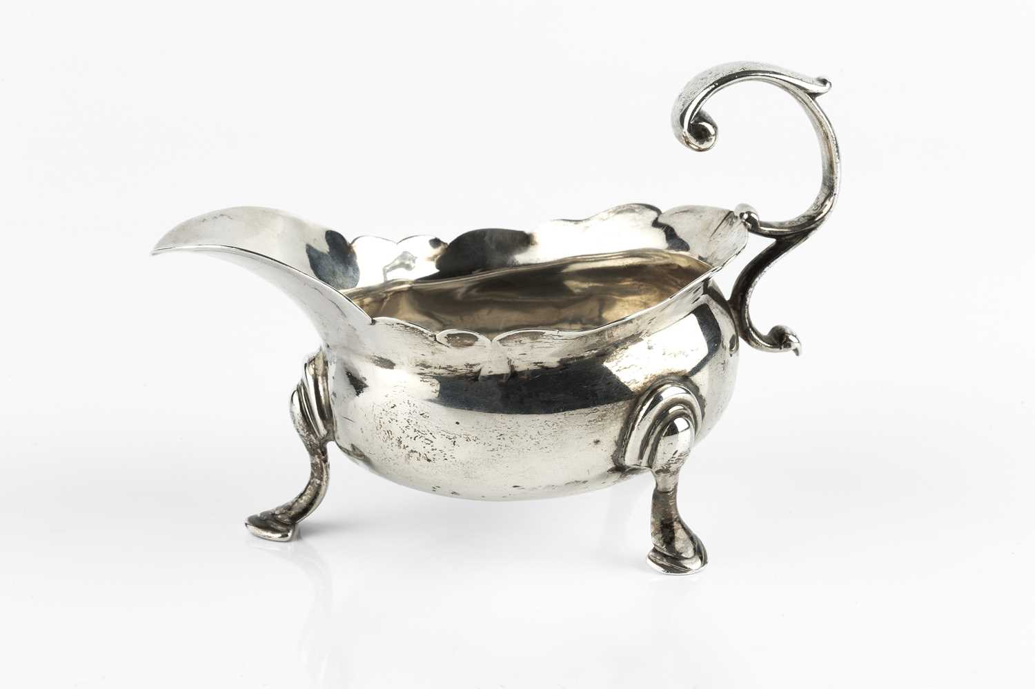 Lot 677 - A George II silver sauce boat, with shaped...