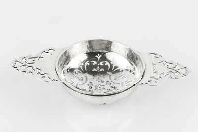 Lot 714 - A George I silver lemon strainer, the bowl...