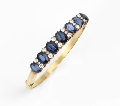 Lot 185 - A synthetic sapphire and diamond line bangle,...