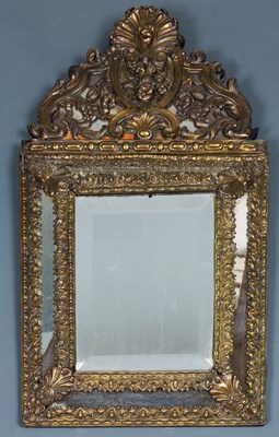 Lot 259 - A bronze repousse cushion frame wall mirror,...