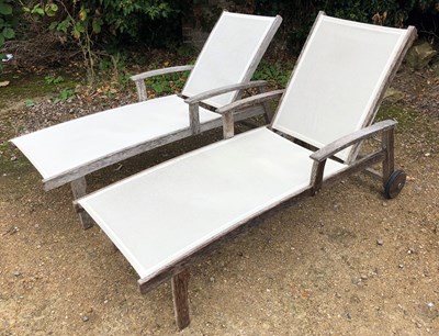 Lot 532 - A pair of teak adjustable sun loungers, with...