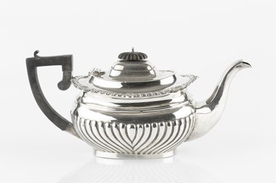 Lot 769 - A silver tea pot, of half lobed form, with...