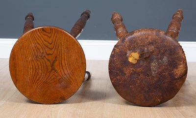 Lot 66 - An antique turned elm stool with dished top,...