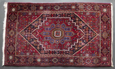 Lot 616 - A Middle Eastern red ground rug with extensive...