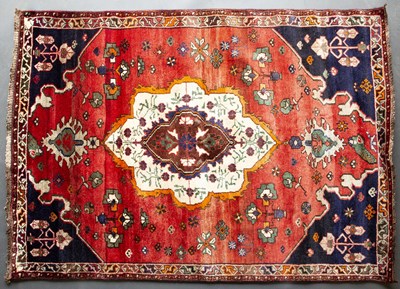 Lot 618 - A Middle Eastern red ground rug with a banded...