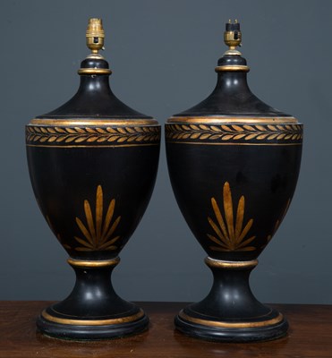 Lot 330 - A pair of black painted parcel gilt ceramic...