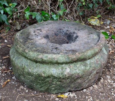 Lot 671 - An ancient round stone quern with partial rim,...