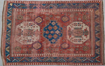 Lot 634 - A Kazak red ground rug with geometric...