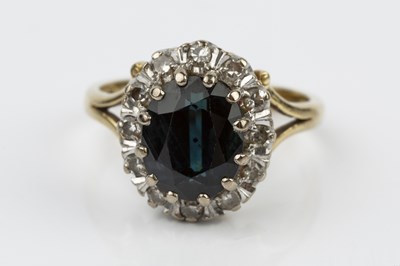 Lot 88 - A sapphire and diamond cluster ring, the oval...