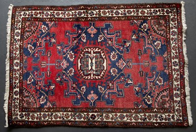 Lot 653 - A Middle Eastern red ground rug with a banded...