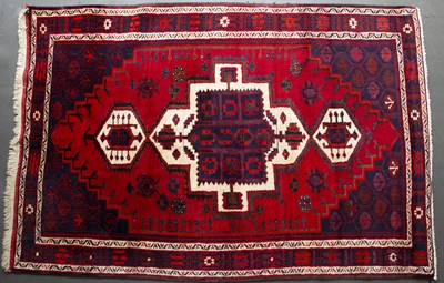 Lot 657 - A Middle Eastern red ground rug with geometric...