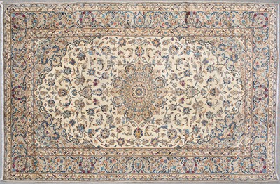 Lot 673 - An Eastern cream ground rug with blue foliate...