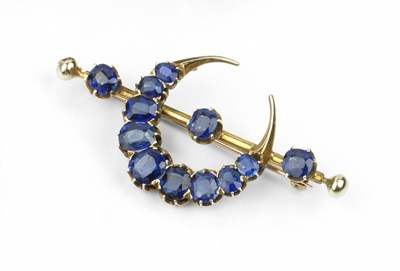 Lot 201 - A sapphire crescent bar brooch, designed as a...