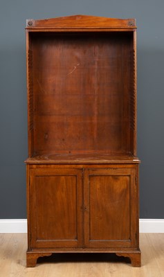 Lot 286 - A mahogany open fronted bookcase with pediment...