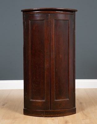 Lot 307 - An 18th century bow fronted oak corner cabinet...