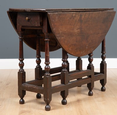 Lot 253 - An early 18th century oak drop leaf gateleg...