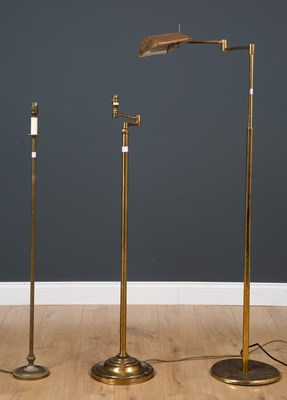 Lot 300 - A collection of three brass floor lamps, one...